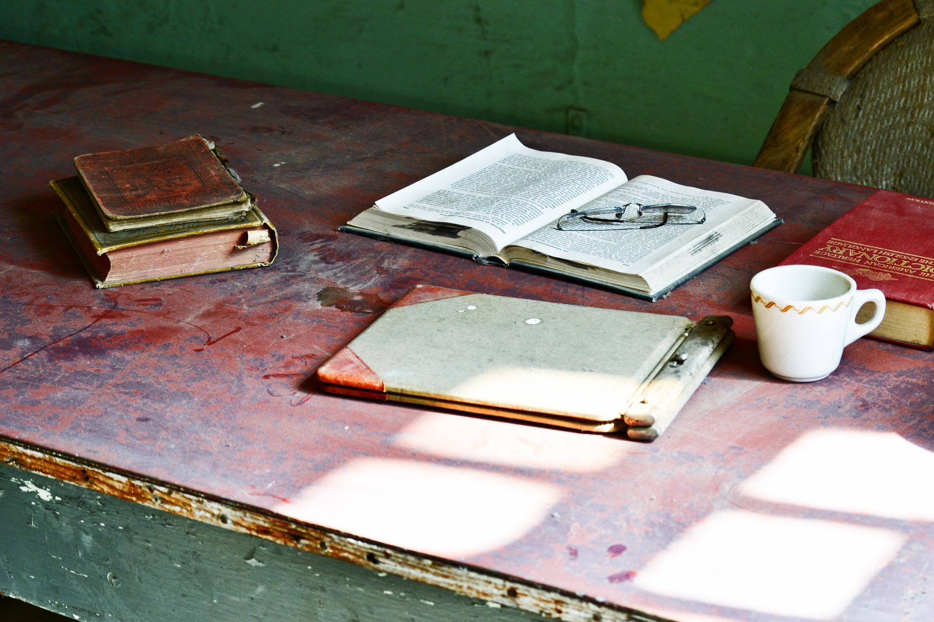 Manuscrit annoté au stylo, carnet de notes et tasse de café posés sur un bureau chaleureux en bois